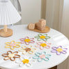 Collection d'anneaux de dentition fleurs pastel sur table blanche style nordique - Bébé Lova