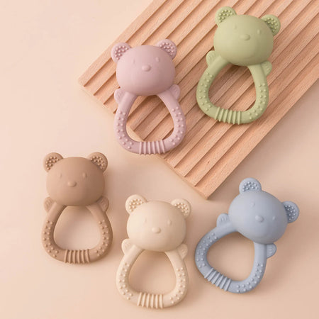 Ensemble d'anneaux de dentition hochets pastel pour bébé présenté sur support effet bois - Bébé Lova