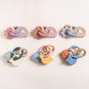 Collection de bracelets de dentition sensoriels bébé avec plusieurs modèles pastel espace et arc-en-ciel - Bébé Lova