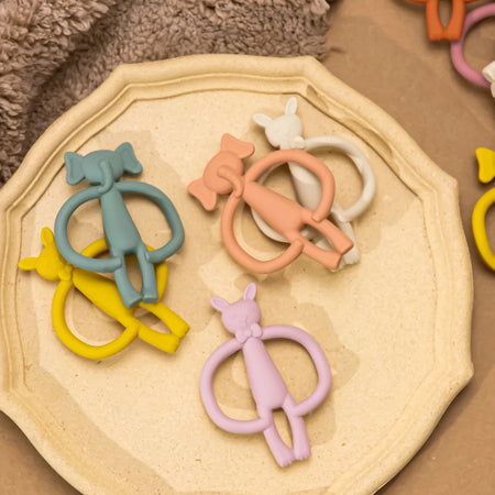 Anneaux de dentition animaux en silicone posés sur une assiette décorative - Bébé Lova