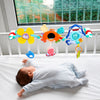 Bébé allongé observant une arche musicale colorée suspendue au-dessus du lit - Bébé Lova