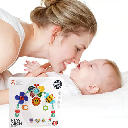 Maman jouant avec son bébé à côté de l’arche musicale sensorielle pour poussette et berceau - Bébé Lova
