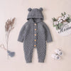 Barboteuse bébé tricot gris à capuche présentée avec petites baskets et fleurs - Bébé Lova