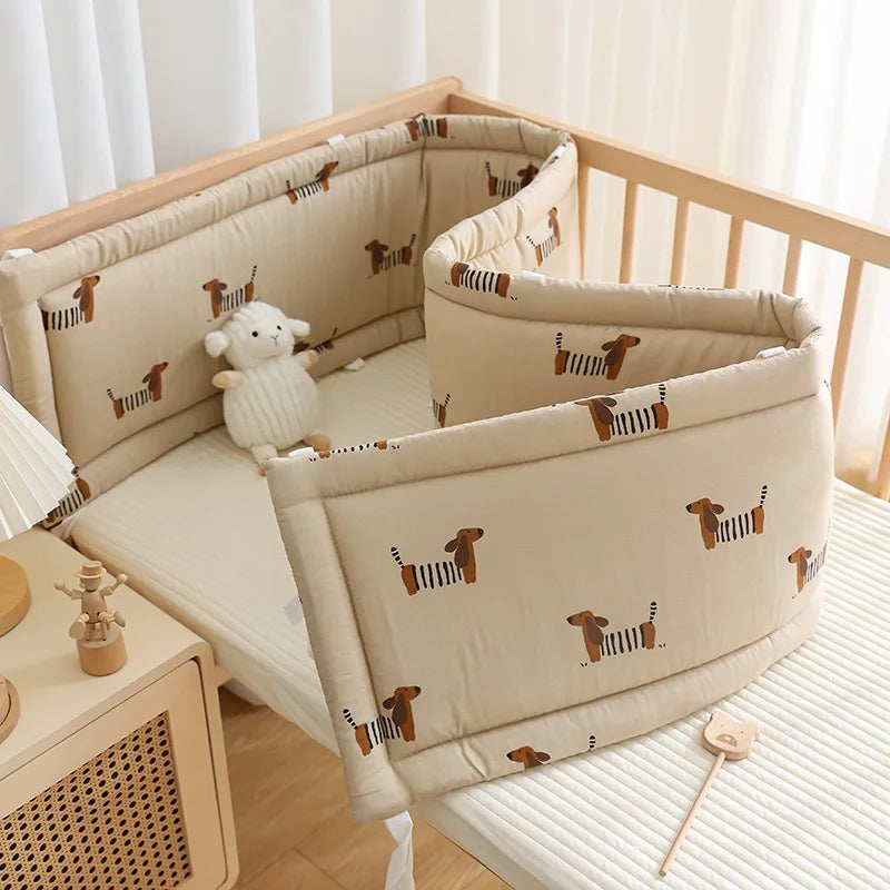 Tour de lit bébé beige motif teckel installé dans un lit bébé en bois naturel - Bébé Lova