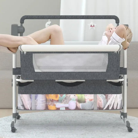 Berceau électrique SmartCrib gris rangement jouets jambes croisées lifestyle - Bébé Lova