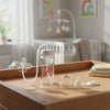 Kit biberon mains libres TriFlow posé sur une table avec accessoires de nettoyage et tétine - Bébé Lova