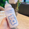 Main tenant un biberon ourson 350 ml pour bébé au style kawaii - Bébé Lova