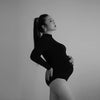 Portrait artistique noir et blanc d’une femme enceinte portant un body noir ajusté - Bébé Lova