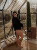 Future maman portant un body de maternité noir extensible dans une serre lumineuse - Bébé Lova