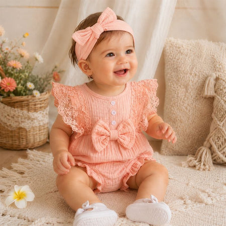Bébé fille souriante portant un body rose avec dentelle et bandeau assorti dans une ambiance douce - Bébé Lova