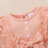 Gros plan sur le body bébé rose poudré avec boutons et dentelle délicate - Bébé Lova