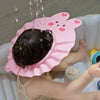 Bébé portant un bonnet de bain rose anti-éclaboussures pendant le bain - Bébé Lova