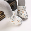 Jambes de bébé portant des bottines fourrées à imprimé ours et triangles - Bébé Lova