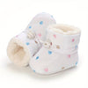 Gros plan sur une paire de bottines bébé blanches fourrées à cœurs brodés colorés - Bébé Lova