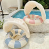 Bouée gonflable enfant rose avec pare-soleil flottant près de la piscine - Bébé Lova