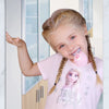 Fillette utilisant sa brosse à dents électrique DinoBrush rose dans la salle de bain - Bébé Lova