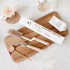 Set de deux brosses de nettoyage en silicone pour biberons et tétines avec sa boîte, posé sur une planche en bois - Bébé Lova