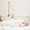 Bébé endormi sous un mobile musical nuage suspendu au lit - Bébé Lova