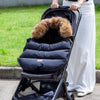 Chancelière évolutive CozyNest noire à col fourrure installée sur une poussette - Bébé Lova