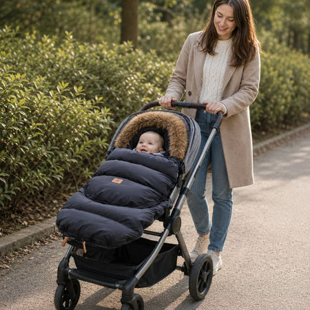Maman promenant bébé bien au chaud dans la chancelière évolutive CozyNest noire à col fourrure - Bébé Lova