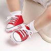 Bébé portant des baskets en toile rouges - Bébé Lova