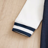 Gros plan sur le poignet blanc à bord rayé bleu marine de la combinaison baseball bébé - Bébé Lova