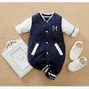 Combinaison baseball bébé bleu marine présentée avec un cadre photo et des chaussures sur fond beige - Bébé Lova