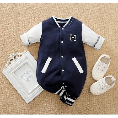 Combinaison baseball bébé bleu marine présentée avec un cadre photo et des chaussures sur fond beige - Bébé Lova