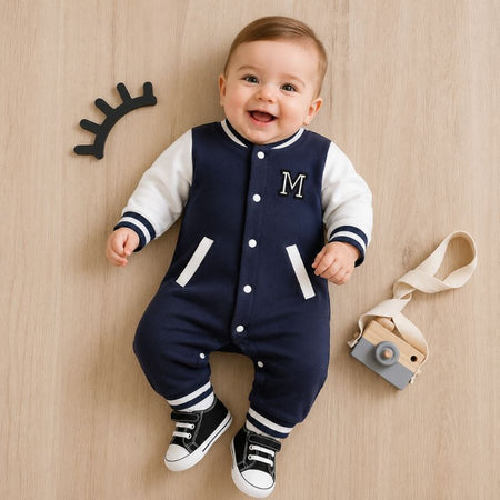 Bébé souriant portant la combinaison baseball bleu marine sur un parquet avec appareil photo en bois - Bébé Lova