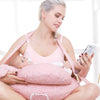 Maman les mains libres avec son téléphone pendant la tétée grâce au coussin d'allaitement NurseWrap et sa sangle - Bébé Lova