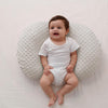 Bébé allongé confortablement sur un coussin d’allaitement blanc en forme U - Bébé Lova