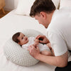 Papa jouant avec son bébé installé sur un coussin d’allaitement moelleux blanc - Bébé Lova