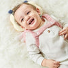 Bébé souriant avec coussin anti-chute rose doux et confortable - Bébé Lova