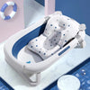 Coussin de bain bébé flottant motif étoiles installé dans une baignoire pliable blanche - Bébé Lova