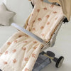 Coussin de siège BearCush écru à motif lapins installé sur une poussette, vue rapprochée avec l'arceau - Bébé Lova