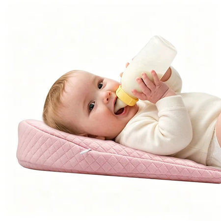 Bébé nourri au biberon sur coussin incliné rose anti-reflux ergonomique - Bébé Lova