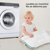 Enfant assis près d'un lave-linge avec l'oreiller cervical lavable en machine qui ne se déforme pas - Bébé Lova