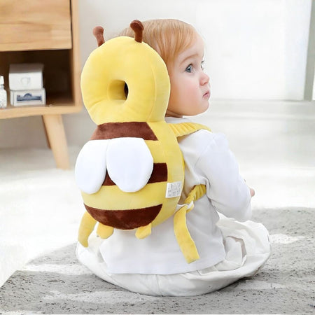 Bébé assis de dos portant le coussin de protection tête abeille - Bébé Lova