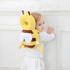 Bébé debout appuyé contre un mur portant le coussin de protection tête abeille - Bébé Lova
