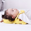 Bébé allongé sur le dos reposant sa tête sur le coussin protecteur abeille - Bébé Lova