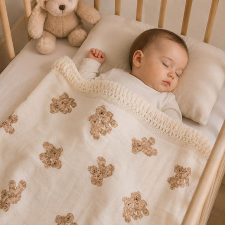Bébé endormi dans son lit sous une couverture en mousseline de coton à motif ours - Bébé Lova