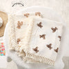 Couverture en mousseline de coton à motif ours pliée sur un plaid en fausse fourrure - Bébé Lova