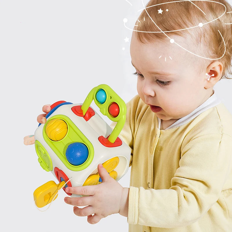 Bébé manipulant cube sensoriel Montessori BusyCube, jouet éducatif favorisant l’éveil et la motricité - Bébé Lova