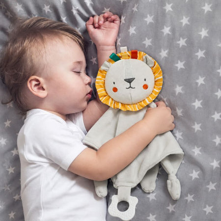 Bébé endormi serrant un doudou plat lion doux et réconfortant - Bébé Lova