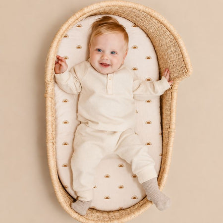 Bébé allongé dans un panier en osier avec drap housse doux pour berceau - Bébé Lova