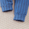 Gros plan sur les bas de pantalon côtelés bleus à revers de l'ensemble bébé - Bébé Lova