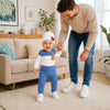 Bébé garçon portant l'ensemble 3 pièces ColourSet bleu et blanc, debout avec son papa qui le tient par la main lors de ses premiers pas dans le salon - Bébé Lova
