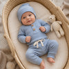 Bébé en couffin vêtu de l'ensemble côtelé bleu, body manches longues et pantalon - Bébé Lova