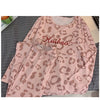 Ensemble pyjama allaitement rose léopard présenté plié sur un lit - Bébé Lova