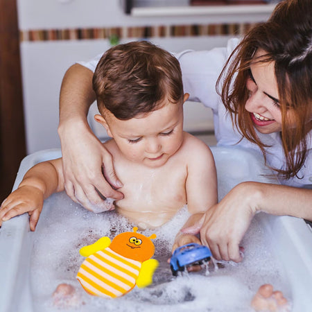 Bébé dans son bain avec maman et gant de bain abeille cartoon flottant - Bébé Lova